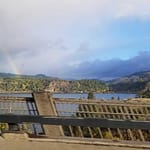 Columbia River Gorge with rainbow over water 